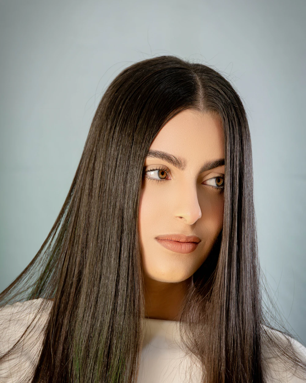 Femme aux longs cheveux bruns parfaitement lisses et brillants